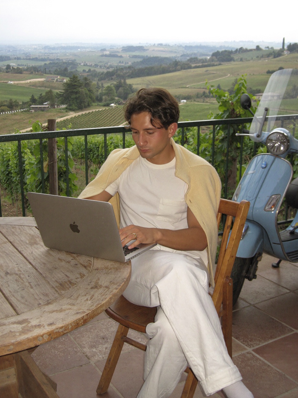 Valentino Vargas trabajando con su portátil en una terraza entre viñedos